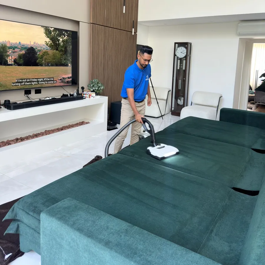 Desacarização de sofá verde numa sala ampla de apartamento