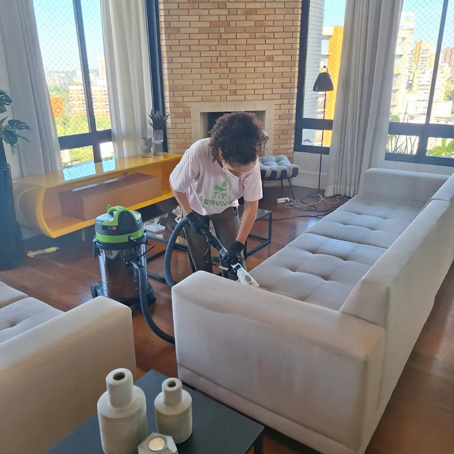 Sofá branco sendo higienizado numa sala com lareira